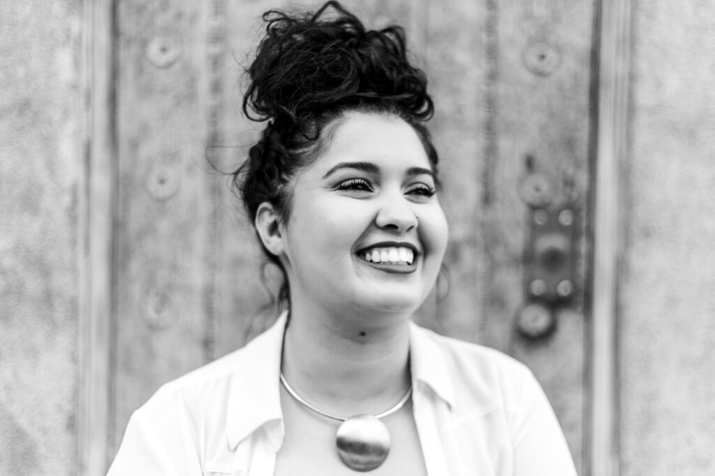 Black and white photo of author in collared shirt and large circle necklace