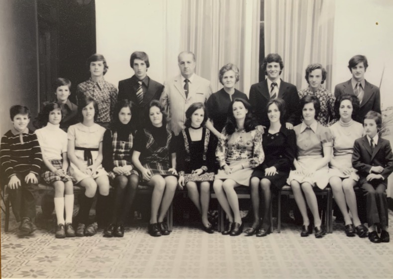 A sepia toned family photo from the late 70s or early 80s with two parents and seventeen children.