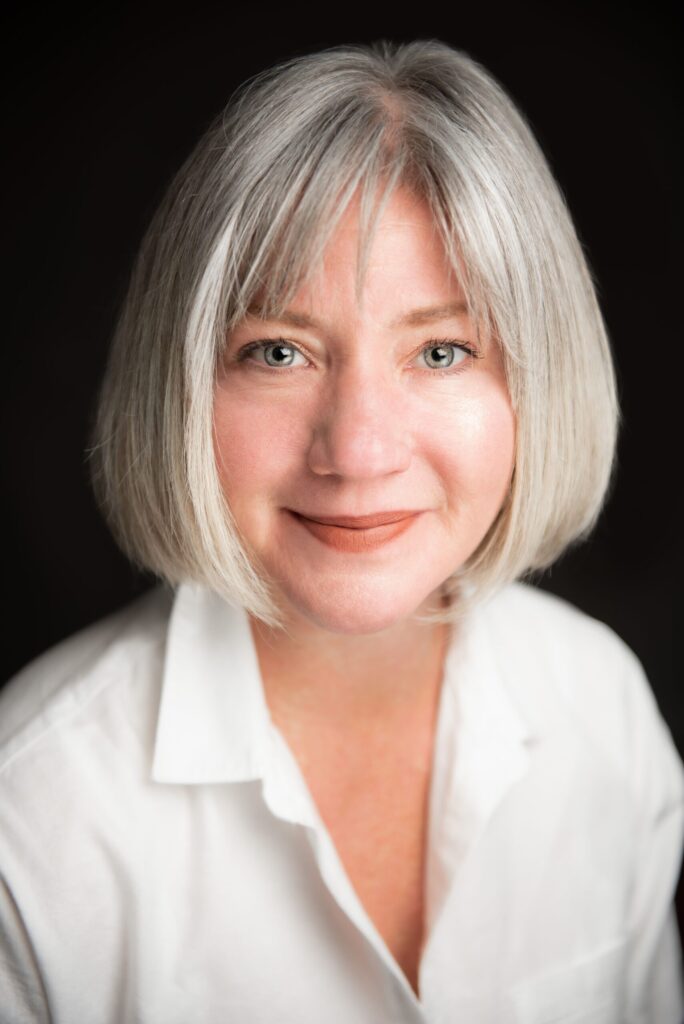 Rebecca Lindenberg, a white woman with a gray bob, smiles at the camera.